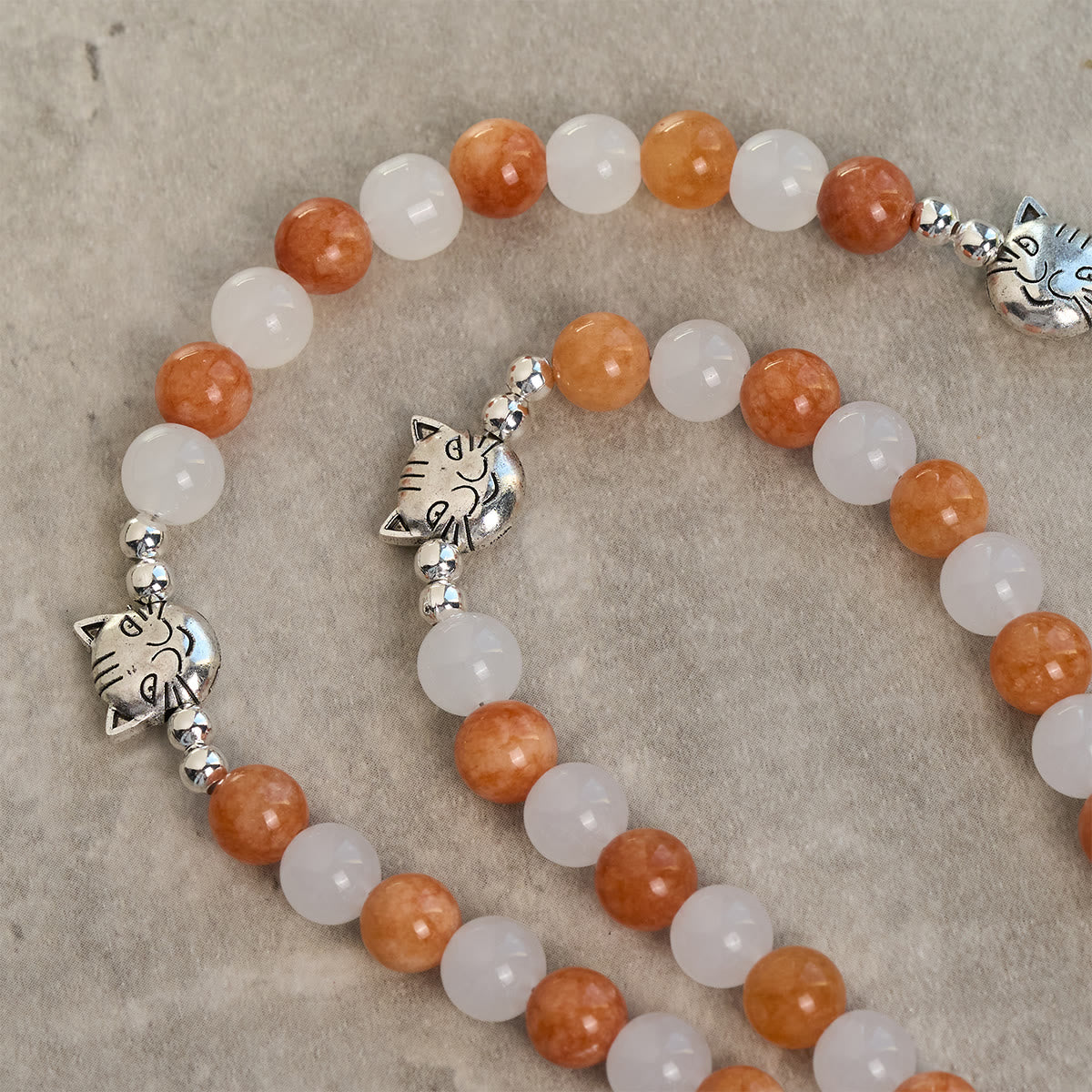 Pulsera de Cuarzo Naranja y Blanco con Dijes de Gato Atigrado en Acero, Rosario Animal