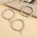 Pulsera Elegante de Cuentas Blancas y Doradas con Cruz: Gracia Pura Cada Día