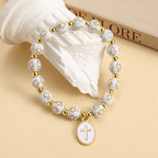 Pulsera Elegante de Cuentas Blancas y Doradas con Cruz: Gracia Pura Cada Día