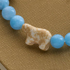 Pulsera Artesanal de Cruz con Cuentas Azules Oso Polar: Salvemos a los Osos Polares